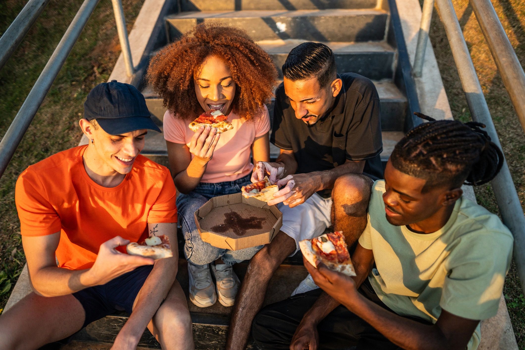 Friends sharing pizza outdoors together